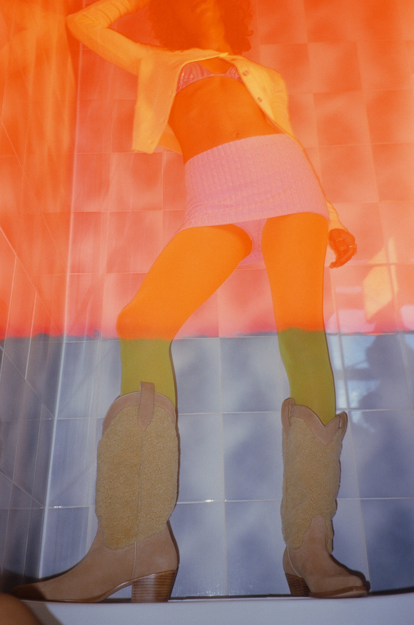 Marina standing on bath wearing suede and shearling cowboy boots.