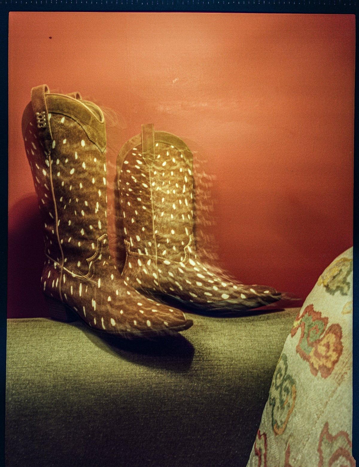 Still life of wild Fawn calf hair cowboy boots on sofa