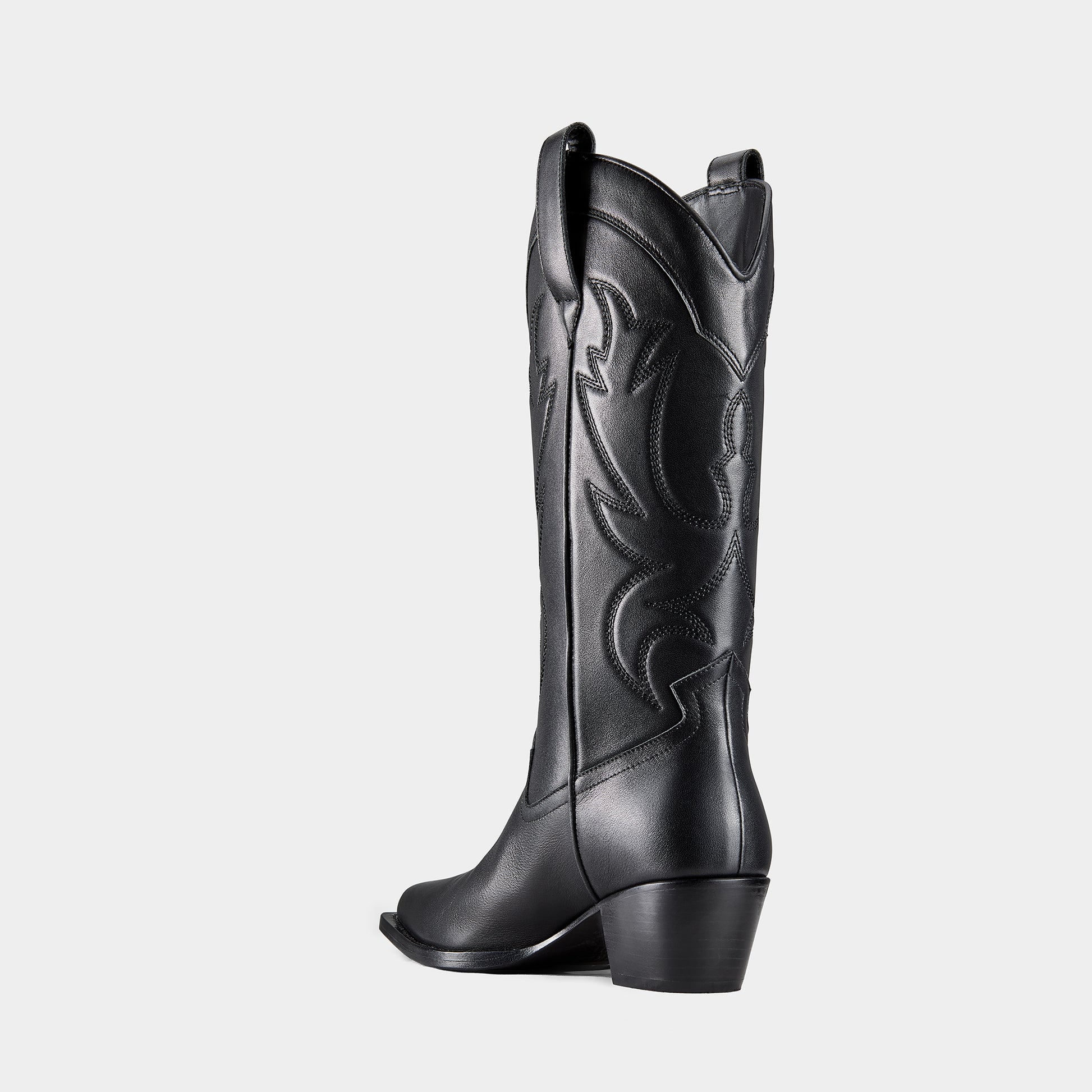 Black cowboy boot with embroidered design and metal branding on a light grey background - back view.