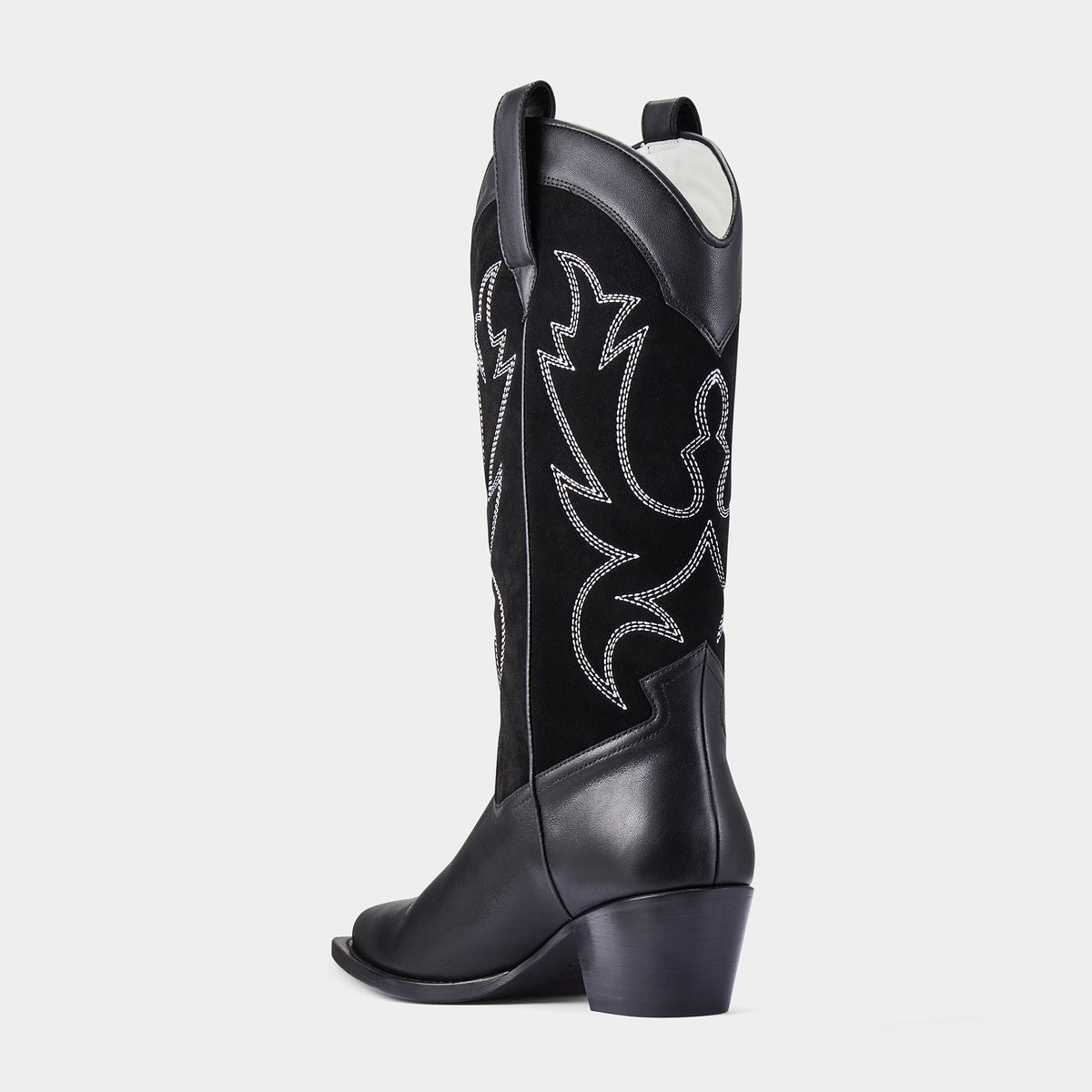 Black cowboy boot with decorative patterns on a light grey background - back angle