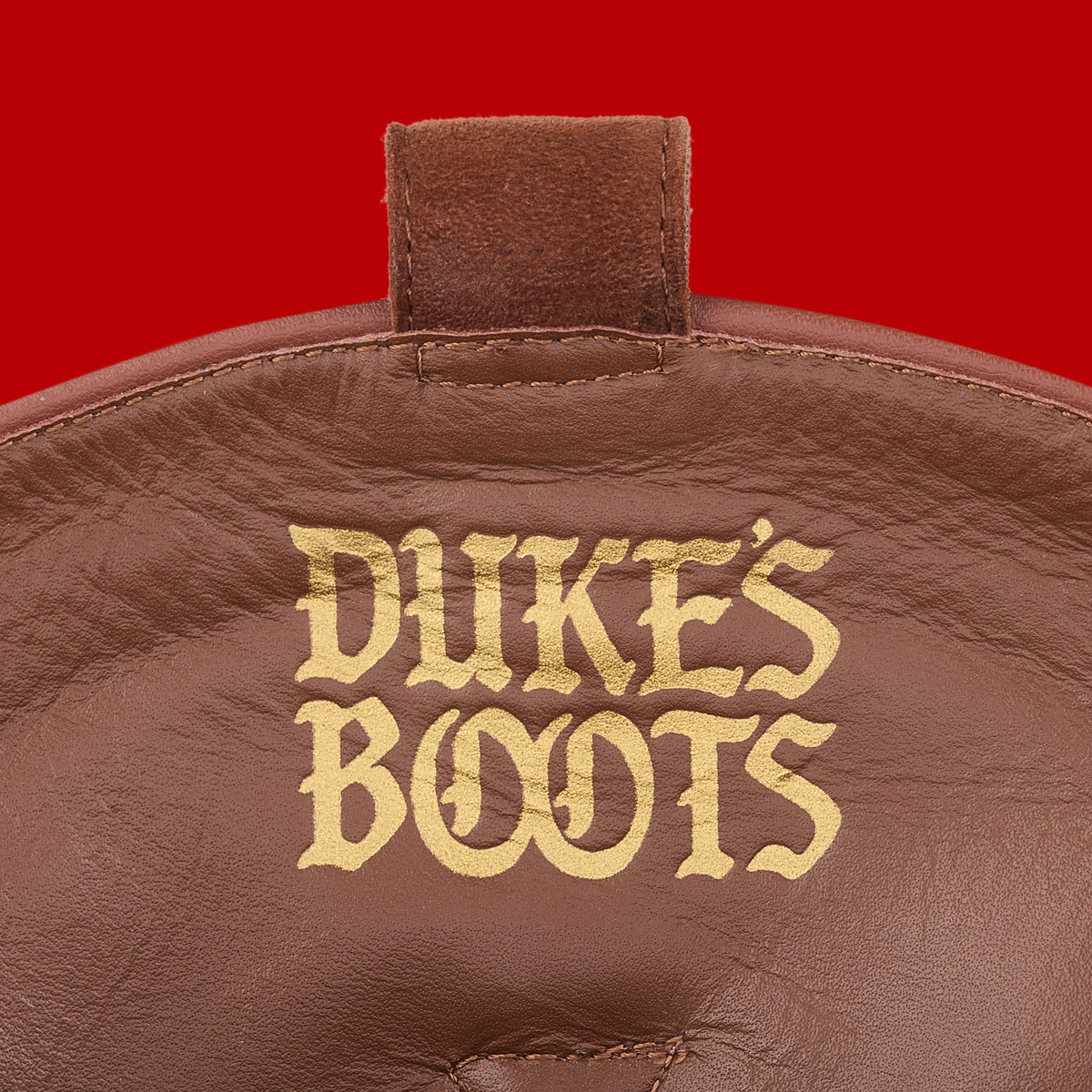 Internal view of cognac suede cowboy boot with tan lining and gold debossed logo