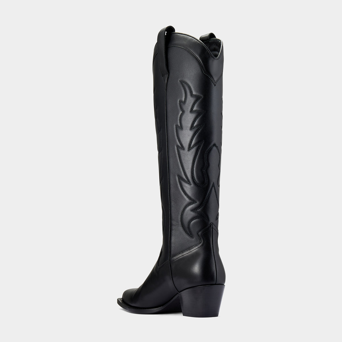 Black knee-high cowboy boot with a black embroidery design on a light grey background - side angle