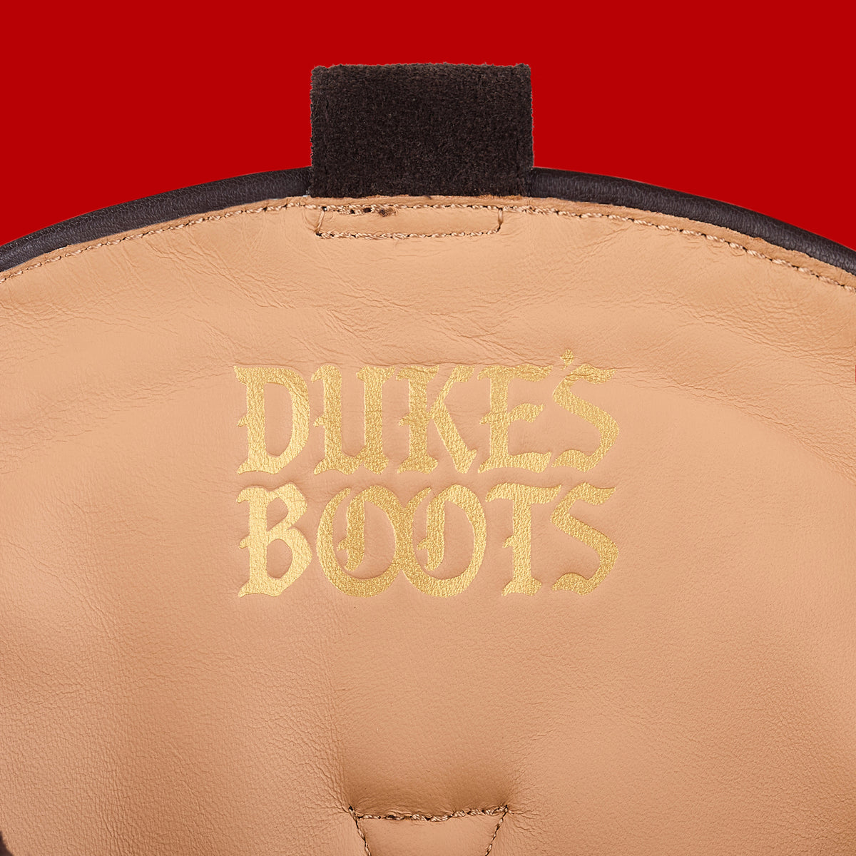 Internal view of tall cocoa cowboy boot with tan lining and gold debossed logo