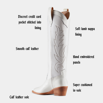 White cowboy boot with embroidered details on a white background